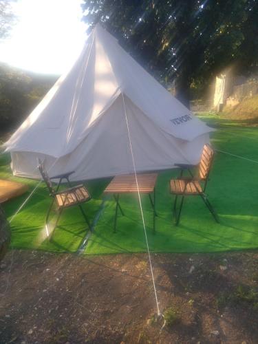 a white tent with two chairs and a table at Avantura Kamp in Jošanica