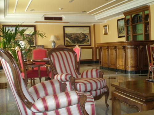 a living room filled with furniture and a large window at Hotel II Castillas Ávila in Ávila