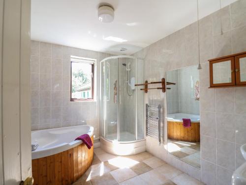 ein großes Badezimmer mit Badewanne und Dusche in der Unterkunft Spring Cottage in Lynton