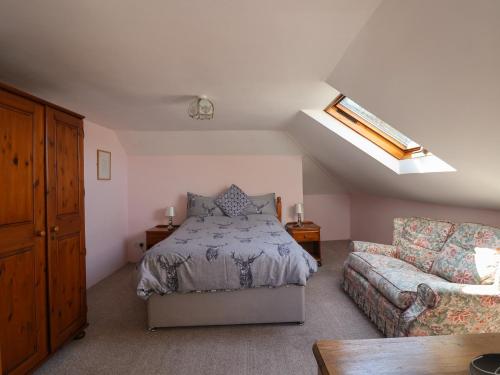 ein Schlafzimmer mit einem Bett und einer Couch in der Unterkunft Spring Cottage in Lynton
