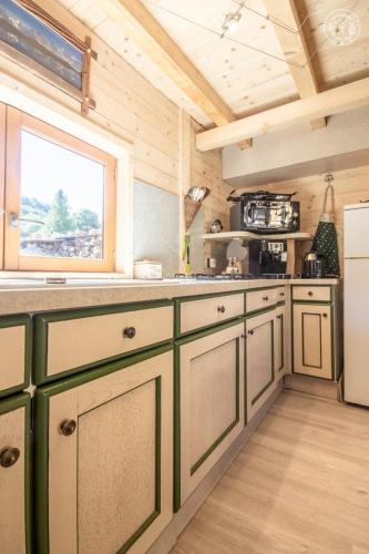 a kitchen with green cabinets and a window at Les inseparables in Saint-Pierre-de-Curtille