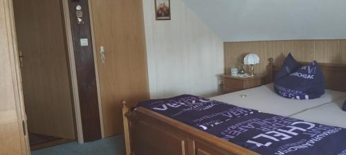 a bedroom with a bed with blue pillows on it at Pension Romann und Bauernferienhof in Annaburg