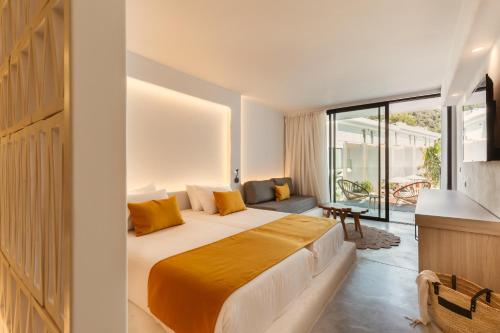 a bedroom with a large bed and a balcony at Nativo Hotel Ibiza in Santa Eularia des Riu