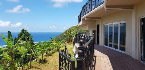 a balcony of a house with a view of the ocean at Amanda Villa - Best Value Mountain top Inn in Au Cap