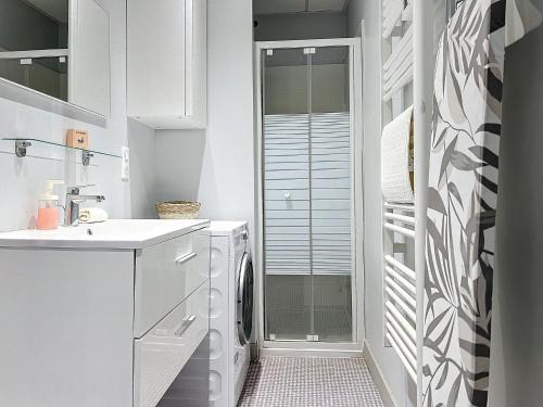 La salle de bains blanche est pourvue d'un lave-linge et d'un sèche-linge. dans l'établissement Le Saint Antoine, à Toulouse