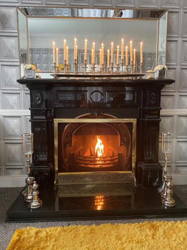 a fireplace with lit candles on top of it at Mount Eagle - Sleeps 24 in Limerick