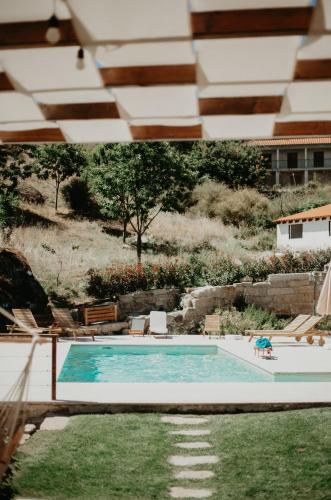 a view of a swimming pool with chairs and a yard at Casa do Bó Nel in Valpaços