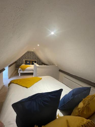 a bedroom with a bed with blue and yellow pillows at Killorglin Irish Pub With Hot Tub That Sleeps 19 in Killorglin
