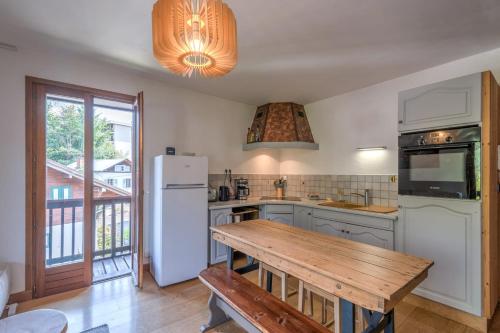 - une cuisine avec des appareils blancs et une table en bois dans l'établissement Duplex de Miage - Welkeys, à Saint-Gervais-les-Bains