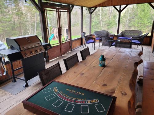 a wooden table in a screened in porch with a stove at Spa Nature Estrie in Saint-Herménégilde