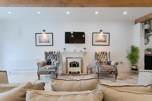 a living room with a fireplace and a tv on the wall at Holland House No3 in Droíchead an Chláir