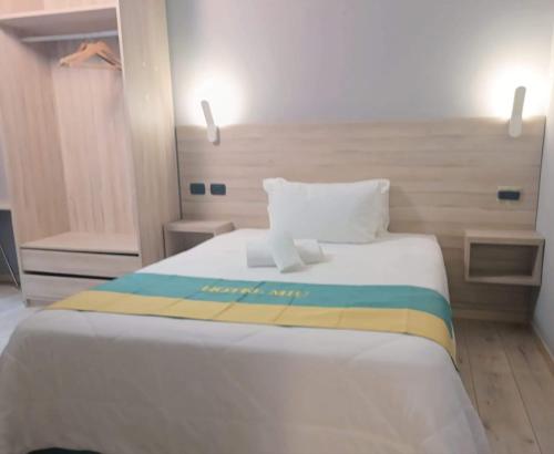 a bedroom with a white bed with a colorful blanket at Miu Hotel in Milan