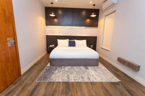 a bedroom with a bed with a rug on the floor at Riivana Tavern in Lekki