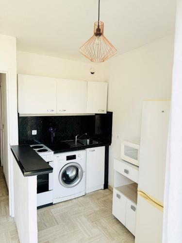 une cuisine avec un évier et une machine à laver dans l'établissement Studio Cannes Marina Jean Bart, à Mandelieu-la-Napoule