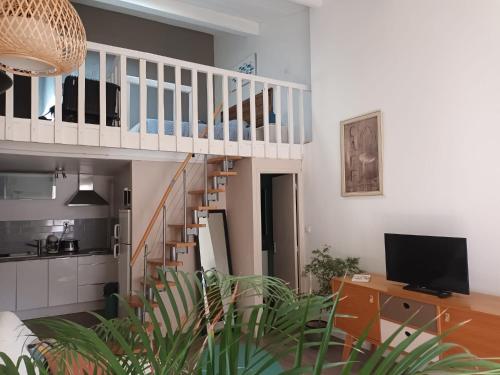 un salon avec un escalier et une télévision dans l'établissement Jolie appartement centre Palavas les Flots, à Palavas-les-Flots