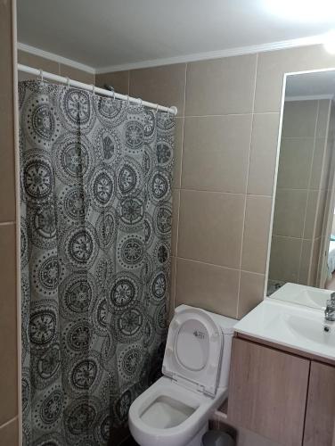 a bathroom with a toilet and a shower curtain at Departamento nuevo 3 dormitorios, Temuco in Temuco