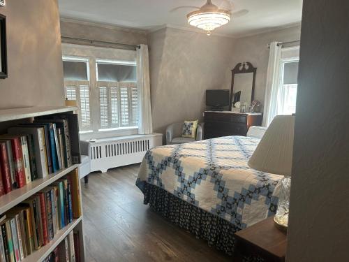 a bedroom with a bed and a book shelf with books at Belgravia B&B in Truro