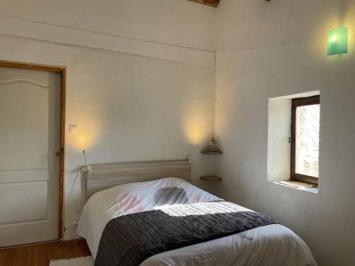 une petite chambre avec un lit et une fenêtre dans l'établissement L'Oustal de la Calade, à Valleraugue
