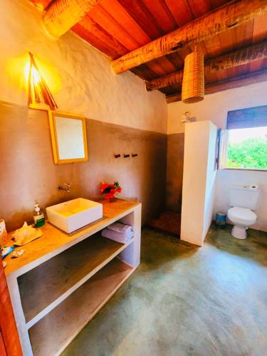 a bathroom with a sink and a toilet in a room at Chalé Charmoso das Ubaias in São Miguel do Gostoso