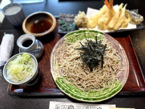 a plate of noodles and other foods on a table at 秘密基地白子ベース in Shirako