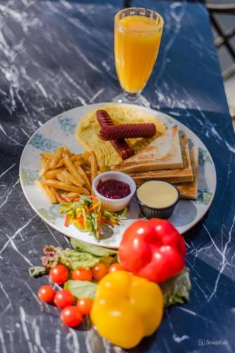 a table with a plate of food and a glass of orange juice at Pyramids Sunshine View in Cairo