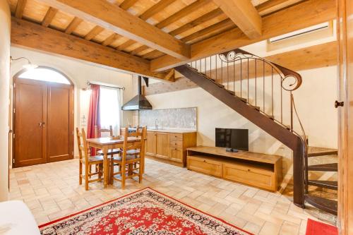 a living room with a staircase and a table with a television at Agriturismo Le Bosche in San Marino