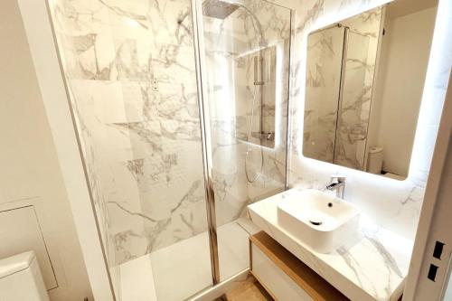 une salle de bain blanche avec un lavabo et une douche dans l'établissement Studio moderne avec parking - Quartier Montchat, à Lyon