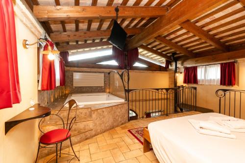 a room with a tub and a table and a bed at Agriturismo Le Bosche in San Marino