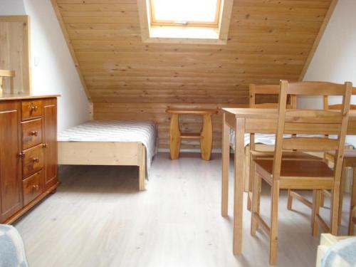 ムジャシフレにあるPokoje Gościnne Za Sichłąのベッド、テーブル、椅子が備わる客室です。