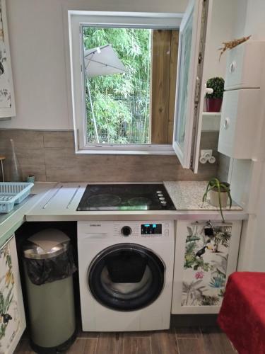 une cuisine avec un lave-linge sous une fenêtre dans l'établissement Charmante petite maison à 15 min de Paris, à Villemomble