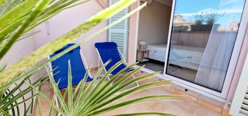 d'un balcon avec une chaise bleue et une fenêtre. dans l'établissement 4 Le Saint Joseph city center of Antibes with AC, à Antibes