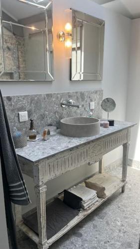 une salle de bain avec un lavabo et un miroir dans l'établissement écrin de verdure, à Saint-Rémy-de-Provence