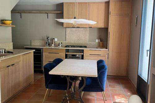 - une cuisine avec une table et des chaises bleues dans l'établissement écrin de verdure, à Saint-Rémy-de-Provence