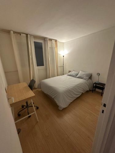 une chambre avec un lit, une table et une fenêtre dans l'établissement T2 lumineux à 15 minutes de Paris, à Colombes