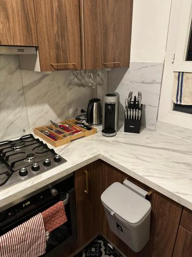 une cuisine avec une cuisinière et un comptoir dans l'établissement T2 lumineux à 15 minutes de Paris, à Colombes