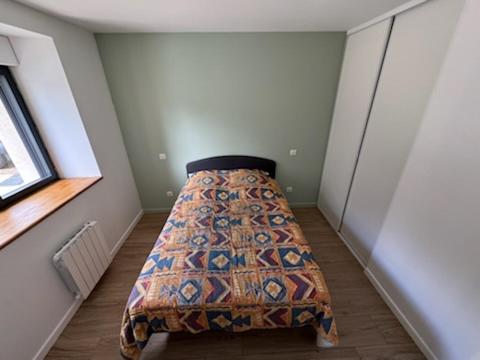 une chambre avec un lit dans le coin d'une pièce dans l'établissement Vielle grange rénovéeTout confort, à Comps-la-Grand-Ville