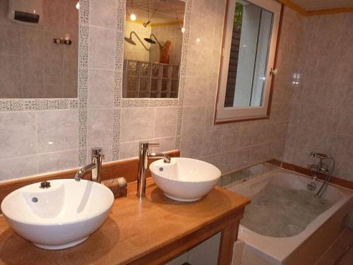 a bathroom with two sinks and a tub at La suite du paysan terrasse privative avec salon de jardin et bain de soleil cuisine privé bain à remous privatif plage de sable fin à 7 mn in Tréméoc