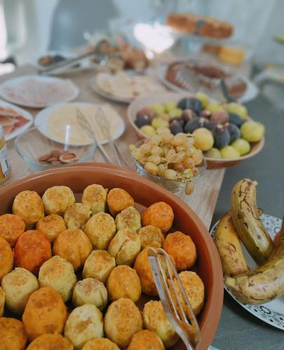 a table with plates of food and bowls of fruit at Sienda Cesira in Muravera