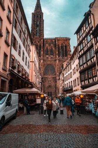 a group of people walking down a street in front of a cathedral at ibis Styles Strasbourg Nord Palais des Congrès in Schiltigheim