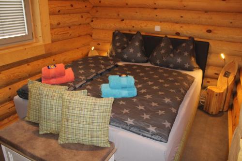 ein Schlafzimmer mit einem Bett in einer Blockhütte in der Unterkunft Blockhaus eighteen in Rieden