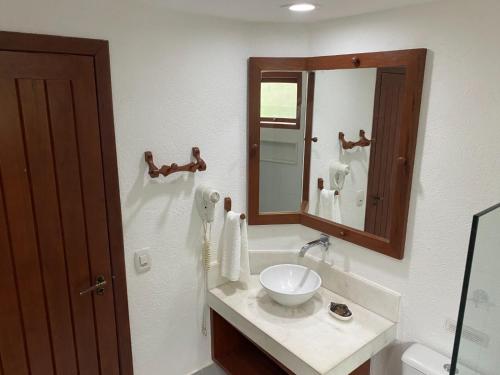a bathroom with a sink and a mirror at Pousada Coisa e Tao in Arraial d'Ajuda