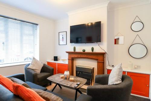 a living room with a fireplace and a tv at Beautiful 3 Bedroom House - Sleeps 5 Free Parking in Longley