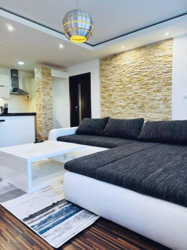 a living room with a couch and a table at Moderný 2-spálňový apartmán Twins White s balkónom in Michalovce