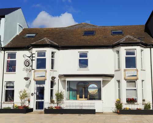 una casa blanca con un escaparate en Mourne Mountain Art Apartments, en Newcastle