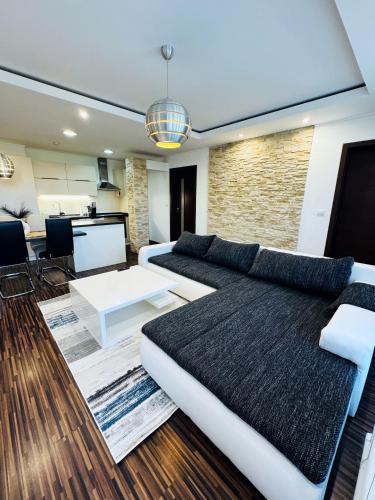 a living room with a couch and a table at Moderný 2-spálňový apartmán Twins White s balkónom in Michalovce