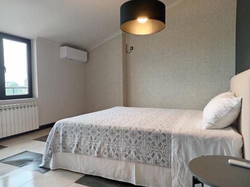 ein Schlafzimmer mit einem weißen Bett und einem Tisch in der Unterkunft Medea's Home in Kutaissi