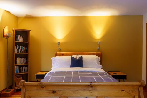 a bedroom with a bed with a yellow wall at La Romane Unique Chalet Billard, Spa & Pool in Val-David