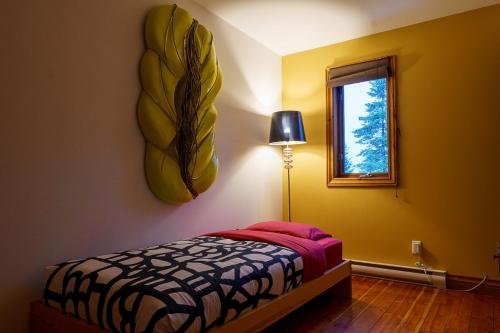 a bedroom with a bed and a window at La Romane Unique Chalet Billard, Spa & Pool in Val-David