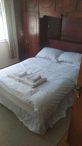 a bed with white sheets and towels on it at Cheerful 3 bedroom house with fantastic views in Shercock
