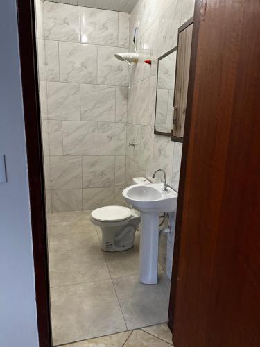 a bathroom with a toilet and a sink at Casa completa privativa in Foz do Iguaçu